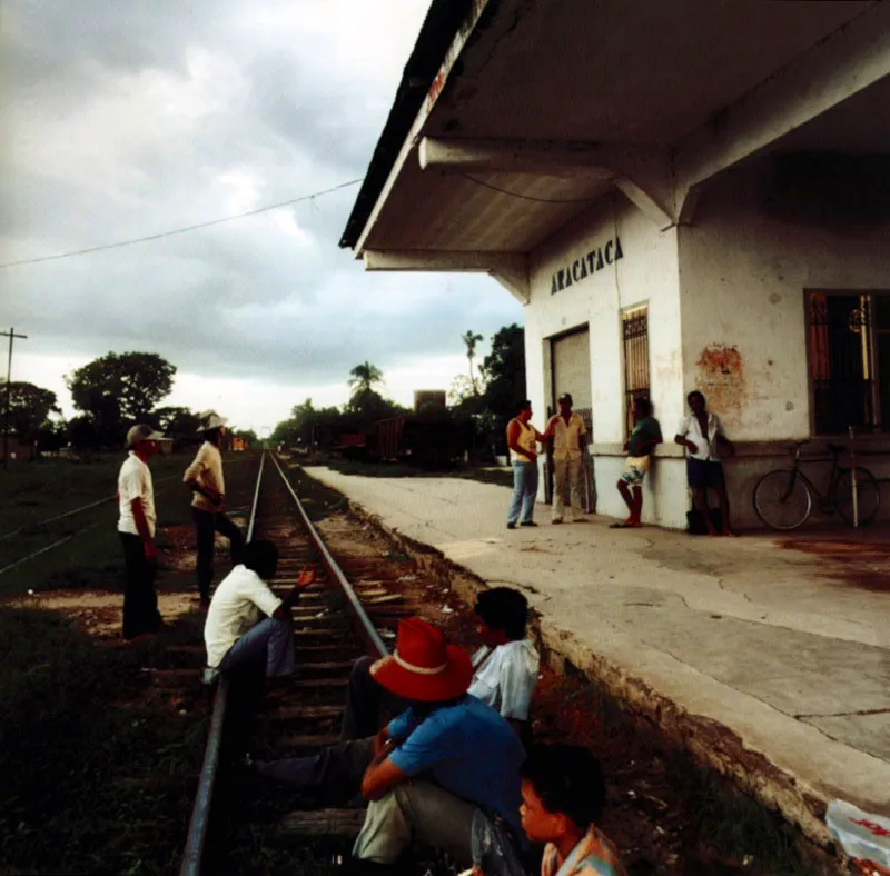 La estacin. / Entonces vea el pueblo al otro lado de la lnea —ya encendidas las luces— y le pareca que, con slo verlo pasar, el tren lo haba llevado a otro pueblo. Tal vez de ah vino su costumbre de asistir todos los das a la estacin, incluso despus de que ametrallaron a los trabajadores y se acabaron las plantaciones de bananos y con ellas los trenes de ciento cuarenta vagones, y qued apenas ese tren amarillo y polvoriento que no traa ni se llevaba a nadie. / Un da del sbado. Hannes Wallrafen