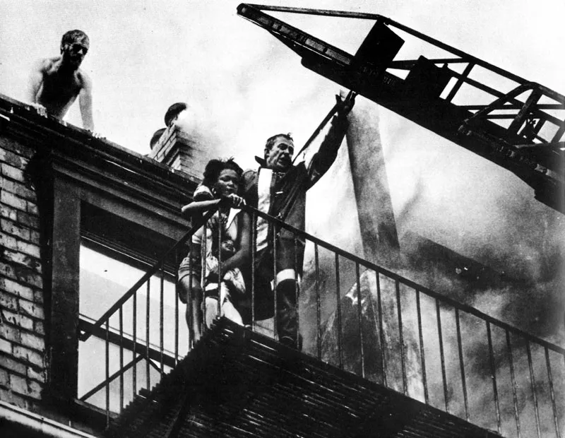 Un edificio se incendia en Boston; el fotografo corre al patio trasero y descubre los esfuerzos intiles de un bombero por rescatar a una muchacha y una nia. Ambas caen al vaco; la muchacha muere. (Stanley Forman, 1975). 