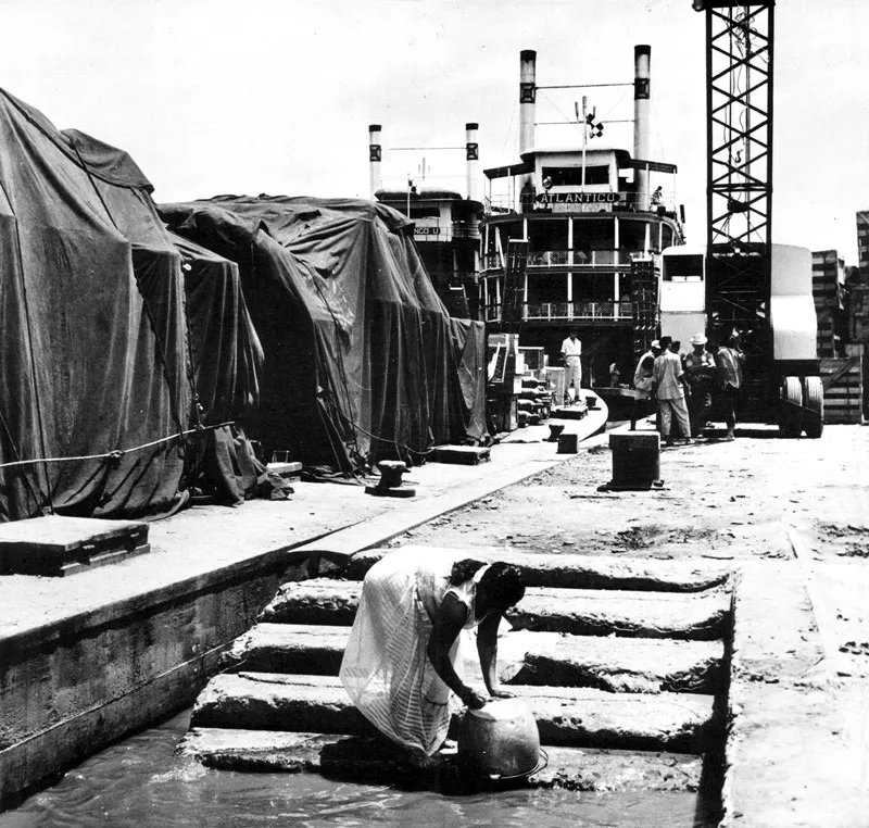 Indiferente al gran mivimiento, las aguas del río sirven para la limpieza de los utensilios domésticos de los vendedores del Muelle en Barranca, en la época de los barcos de rueda. (Nereo).