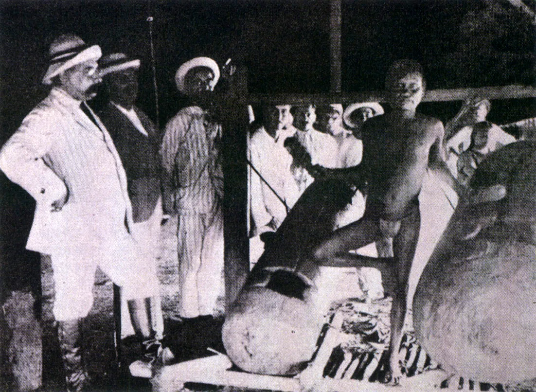 El cónsul británico Mitchel ?destacado en Iquitos a mediados del decenio de 1910?, de visita en una comunidad Witoto, delante de los ???tambores(xilófonos) manguaré ?hembra? y