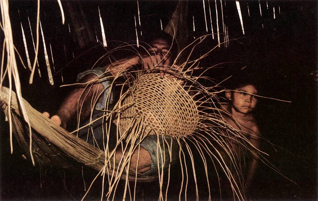 Hombre Yukuna tejiendo un canasto para que su mujer transporte yuca desde la chagra. Entre los grupos indígenas amazónicos el trabajo y la recreación guardan una estrecha relación.