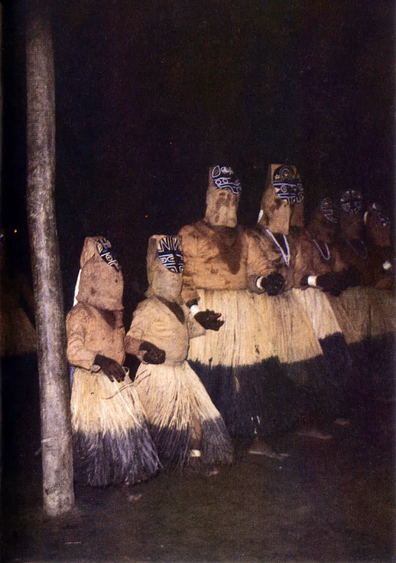 Interior de maloca durante el baile de chontaduro. Sólo los hombres mayores y los niños participan en la personificación de espíritus y animales, mientras las mujeres los acompañan, silen. ciosas, en la periferia.