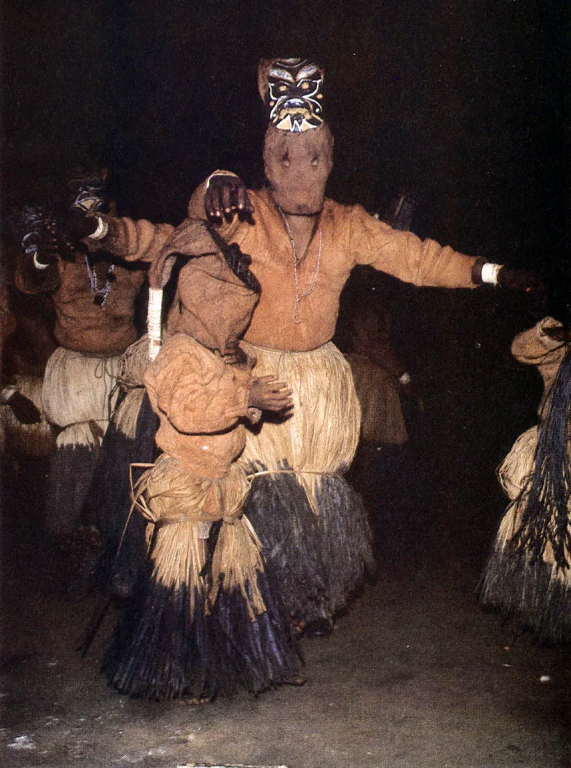 Interior de maloca durante el baile de chontaduro. Sólo los hombres mayores y los niños participan en la personificación de espíritus y animales, mientras las mujeres los acompañan, silen. ciosas, en la periferia.