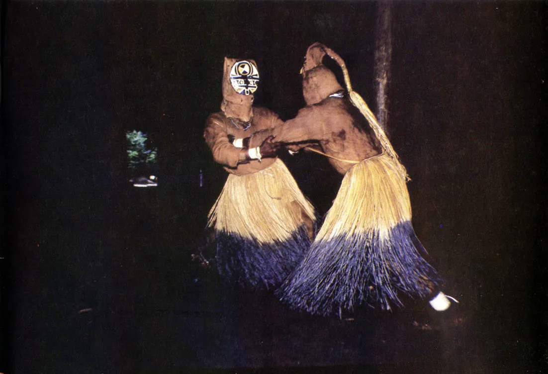 Interior de maloca durante el baile de chontaduro. Sólo los hombres mayores y los niños participan en la personificación de espíritus y animales, mientras las mujeres los acompañan, silen. ciosas, en la periferia.