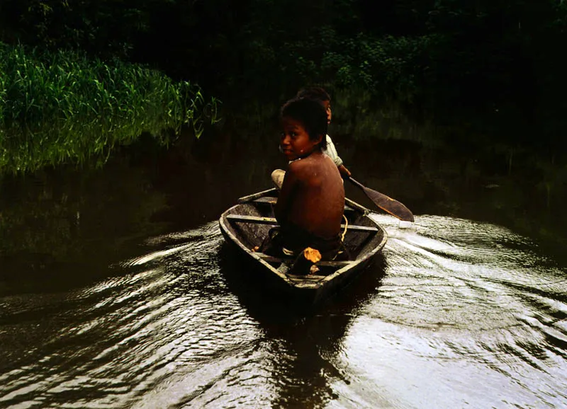 Niños navegando en un afluente del río Amazonas, Amazonas Jeremy Horner