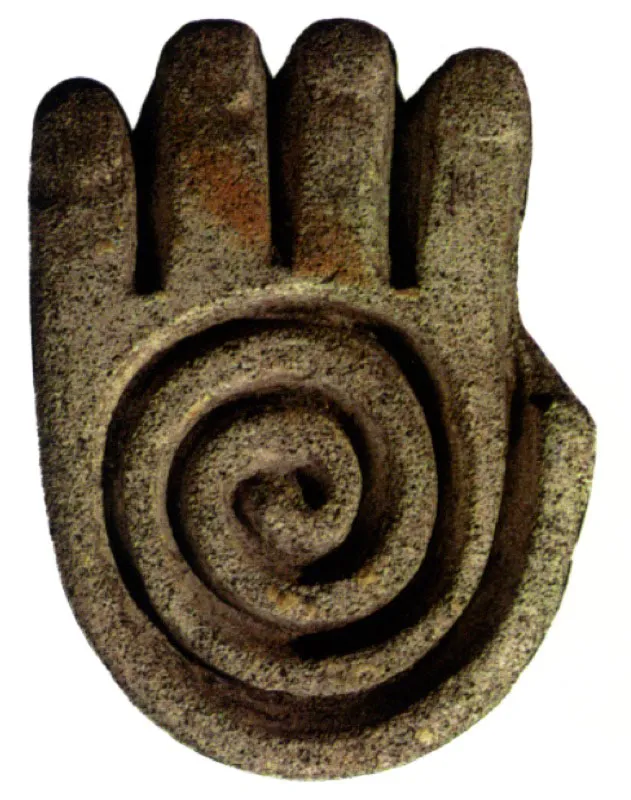 Sello cerámico plano que representa una mano humana con símbolo concéntrico (espiral), en el centro de la palma. Sus características aluden, seguramente, al concepto del “hilo conductor de la vida y al prospecto de su infinita existencia”. Desarrollo Regional Tumaco?La Tolita.