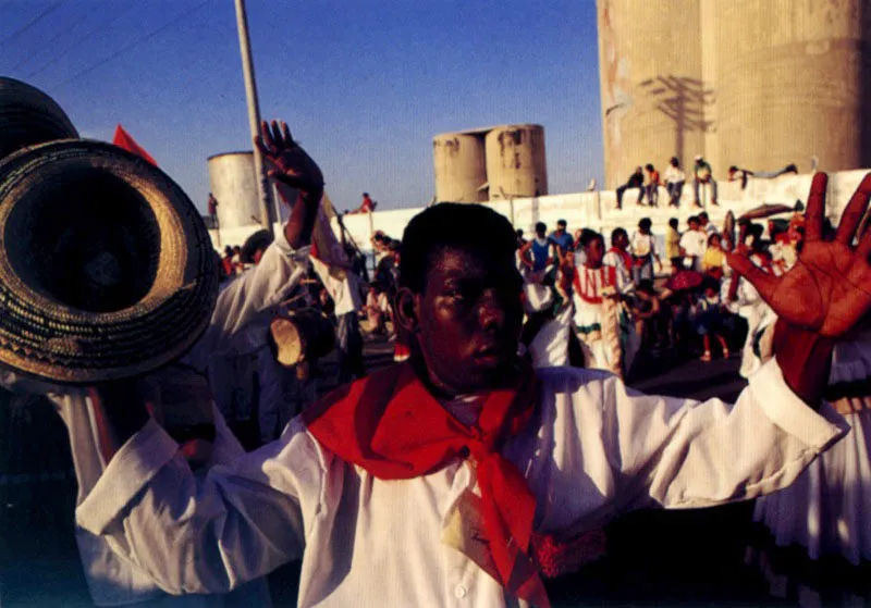 Cipote carnaval!! Reinas populares, pueblos y gentes de la llanura caribe desfilan en la gran parada por las principales calles de Barranquilla el domingo de carnaval. La fanfarria monumental de carrozas, disfraces, comparsas,cumbiambas, comedias, danzas, msica, reinas de los barrios y reina del carnaval, marchan bajo la mirada de miles de espectadores que hora tras hora, debajo de una lluvia de harina, retozan a lo largo del recorrido. Jeremy Horner