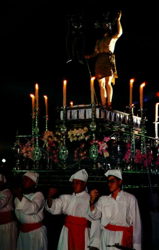 El carguero de santo, vestido de penitente con túnica de fula, alpargatas de suela de fique y capellada de pabilo, lleva la alcayata, o pértiga, un barrote sobre el cual descansa el anda en las pausas de las procesiones. Popayán, Cauca. Jeremy Horner