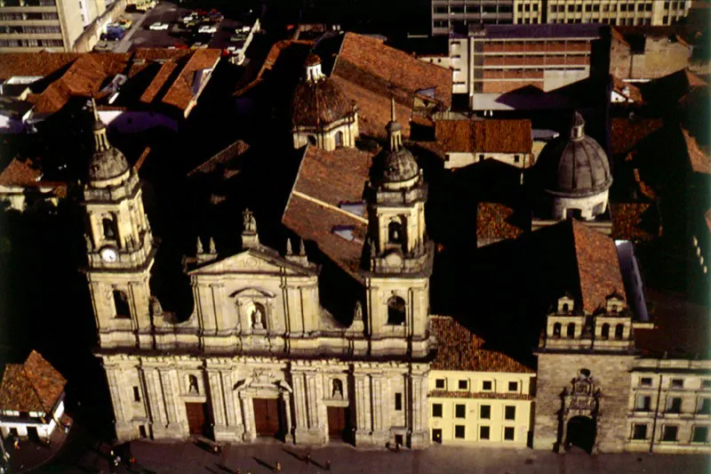 Plaza de Bolvar con la Casa del Florero, la Catedral Primada, la Casa Consistorial y la Capilla del Sagrario. La Casa del Florero, en donde desde 1980 funciona la Casa Museo del 20 de Julio, debe su celebridad al episodio que en 1810 protagonizaron el dueo de la casa, Jos Gonzlez Llorente, y el criollo Francisco Morales. A la Casa del Florero se le incorporaron dos hermosos jardines, uno que da sobre la carrera 7, y otro sobre la calle 11, llamado Jardn de Nario, donde se erigi una rplica del Obelisco de la Libertad diseado por el propio Antonio Nario. En 1925 el arzobispado de Bogot adquiri el edificio de Los Portales de la Casa Consistorial, en el costado suroriental de la Plaza de Bolvar, que amenazaba ruina, lo restaur y estableci all su sede. El edificio, ya ms que centenario, fue consumido por las llamas el 9 de abril de 1948. El arzobispado adelant de inmediato su reconstruccin, y el Palacio Arzobispal, ahora Palacio Cardenalicio, se reinaugur en 1953. La Capilla del Sagrario, iniciada en 1660 por Gabriel Gmez de Sandoval, se concluy en enero de 1700. El pintor Gregorio Vsquez Ceballos, por encargo del constructor, realiz la mayor parte de las obras destinadas a la Capilla. 