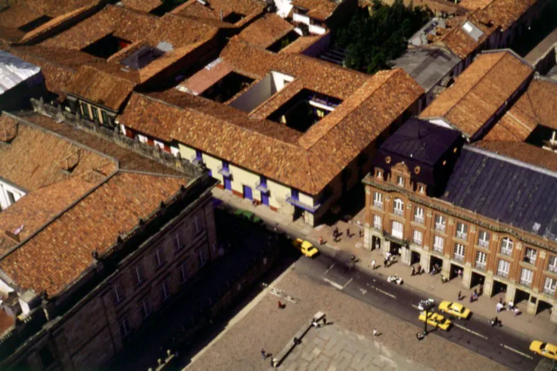 squina de la Plaza de Bolvar, con el Capitolio Nacional, la Casa de Los Comuneros y la Alcalda Mayor. La casona ubicada en la esquina suroccidental de la Plaza de Bolvar es, quiz, la ms antigua de cuantas quedaron en pie para recordarnos la Santaf de la Colonia. Estuvo a punto de ser demolida, pero la intervencin oportuna del maestro Germn Arciniegas, logr que el gobierno nacional destinara la casa para un futuro Museo de Los Comuneros. Esta idea no pudo llevarse a la prctica y, por el contrario, se traslad all el Museo de Desarrollo Urbano, creado e inaugurado en julio de 1969 durante la administracin de Carlos Lleras Restrepo. Este museo, que funcion durante muchos aos en una casa del barrio de La Candelaria, rene toda la historia visual de Bogot, desde su fundacin hasta nuestros das.  El Palacio de la Alcalda Mayor o Edificio Livano tuvo sus orgenes en 1843 cuando Juan Manuel Arrubla emprendi, en el costado occidental de la Plaza Mayor, la construccin del edificio ms grande que se haba proyectado en Bogot, que fue inaugurado cinco aos despus, en 1848. En las galeras del edificio funcionaron por el resto del siglo locales de comercio, oficinas particulares y las dependencias del gobierno municipal. En mayo de 1900, un incendio provocado por manos criminales devor las galeras de extremo a extremo. En 1903, Nicols Livano celebr con la Alcalda un contrato para construir por su cuenta, sobre las ruinas de las galeras, un nuevo edificio, con diseo de Gastn Lelarge y direccin del arquitecto Ricardo Lleras Codazzi, cuyas obras concluyeron en 1907. En 1960 el Palacio Livano pas a ser, en su totalidad, de propiedad del Distrito Capital . 