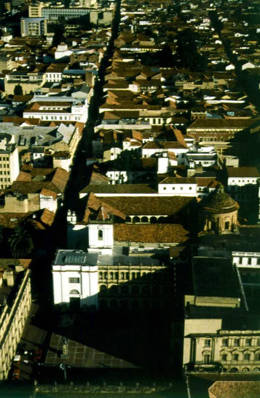 Calle 10ª con la Plazuela Camilo Torres, el Palacio y la Plazuela de San Carlos y el Teatro Colón. Construida para el Sesquicentenario de la Independencia, y en la esquina suroriental de la Plaza de Bolívar, anexa al Colegio de San Bartolomé, la Plazuela Camilo Torres y su estatua son un homenaje al autor del Memorial de Agravios y mártir de la Patria, fusilado en la Plaza de Bolívar en 1816 ❏ “Si hay un lugar en Bogotá, dice Guillermo Hernández de Alba, que permite evocar plenamente lo que fue la ciudad colonial, es este de la pequeña Plazuela de San Carlos, encerrada por casonas coloniales del siglo XVII, que gracias al gusto artístico de sus dueños aún lucen sus balcones corridos, sus tejados corcovados y sus rejas andaluzas”. En esta Plazuela de San Carlos, de nombre oficial Plazuela de Rufino J. Cuervo, y en la casa del médico francés Luis de Rieux, imprimió Antonio Nariño, en su Imprenta La Patriótica, Los Derechos del Hombre ❏ En 1885, después de expropiado por el gobierno nacional el Teatro Maldonado, sus instalaciones fueron demolidas y se inició la construcción de un nuevo teatro cuyos planos fueron encomendados al arquitecto italiano Pietro Cantini, quien dio comienzo a la obra en enero de 1886, que fue inaugurada en octubre de 1892. Se le dio el nombre de Teatro Colón, como parte de los actos conmemorativos del IV Centenario del Descubrimiento de América. Pilar Gómez