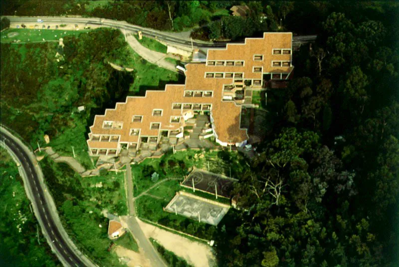 Universidad Distrital Francisco José de Caldas sobre la Avenida de Circunvalación. Fundada en 1948, como dependencia del entonces Municipio de Bogotá. La sede de sus facultades de ingeniería y recursos forestales, de moderna construcción, se encuentra ubicada en el barrio de La Macarena, la cual se edificó a principios de los años ochenta, durante la administración del alcalde Hernando Durán Dussán ❏
59b. Biblioteca Nacional, Parque de la Independencia y barrio Bosque Izquierdo. La Biblioteca Nacional de Colombia, en su primera etapa de Real Biblioteca, fue establecida en 1777, por iniciativa del fiscal Francisco Moreno y Escandón, en el edificio de San Carlos, después Palacio de los Presidentes y hoy sede de la Cancillería. El primer fondo de la Real Biblioteca lo constituían cerca de 5.000 volúmenes expropiados a los padres jesuitas. Durante los veintiocho años en que fue bibliotecario, entre 1791 y 1819, Manuel del Socorro Rodríguez enriqueció el patrimonio de la Biblioteca hasta sobrepasar los 20.000 volúmenes. Hoy, la Biblioteca Nacional cuenta con algo más de veinte fondos y un total que rebasa el millón de volúmenes, además de una hemeroteca inapreciable. En 1933, Daniel Samper Ortega, con planos de Jorge Wills Ferro, inicio la construcción de un gran edificio para la Biblioteca Nacional que fue finalizado en 1938, en los últimos días de la primera administración de Alfonso López Pumarejo ❏ El Bosque Izquierdo formó parte del grupo de barrios elegantes que surgieron en los años treinta. Sus predios eran propiedad de Antonio Izquierdo La Torre, uno de los impulsadores del desarrollo urbano de Bogotá. Aldo Brando