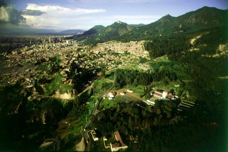 Panormica del sur y centro de la ciudad desde el acueducto de Vitelma. Tanto en el sur como en el norte de Bogot, los cerros orientales han sido objeto de continuas campaas de reforestacin y conservacin, que no slo contribuyen a la purificacin del aire, sino al embellecimiento del paisaje. Desde los tanques de Vitelma se puede observar un panorama reconfortante de bosques y verdor. 