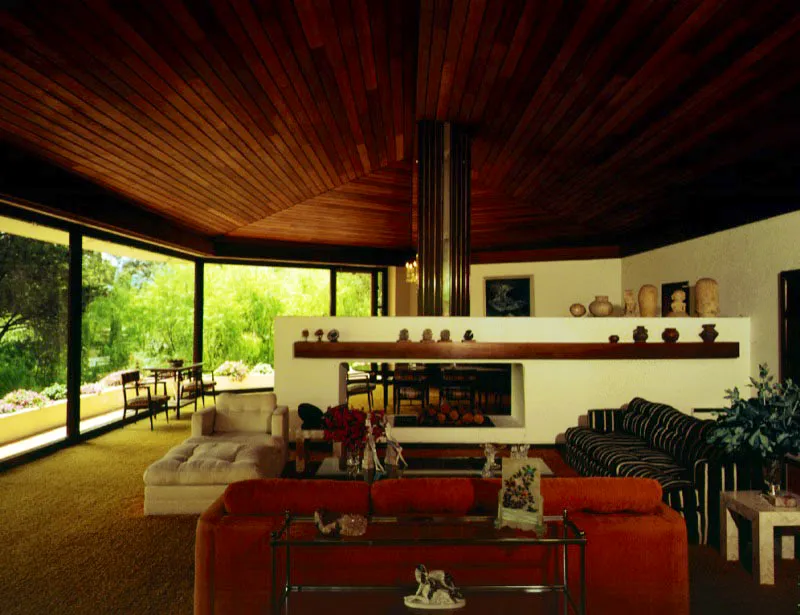 Las ventanas son muros transparentes que cierran y abren al mismo tiempo el espacio interior hacia el paisaje. La chimenea irrumpe con fuerza determinando ámbitos diferentes sin separarlos del todo. El elaborado trabajo del cielo raso en madera sigue las formas de la casa tanto en la planta como en la volumetría. Bogotá, D.C.
Arquitecto, Rafael Obregón.