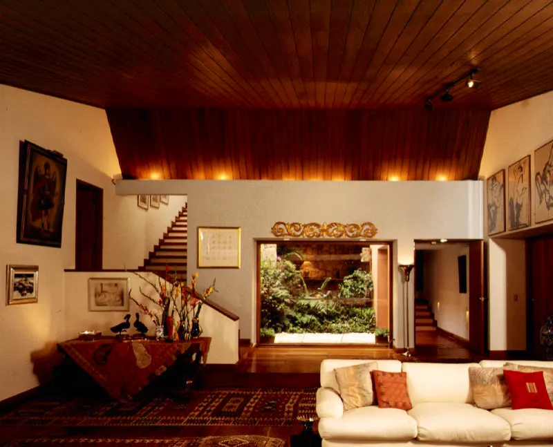 Un pequeño patio inserto en la mitad de la casa provee vista, iluminación y transparencia que permite ver otros recintos. Su espacio reducido favorece un estudio cuidadoso de aperturas y cerramientos. En el interior, el juego con las líneas oblicuas de las barandas y el cielo raso mediatiza la ortogonalidad generadora de toda la casa. / Bogotá, D.C. Arquitecta, Cecilia Cifuentes de Caro.