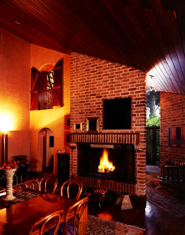 La delimitación de un espacio puede combinar precisión y ambigüedad, según la posición del observador; puede ser clara y al mismo tiempo crear expectativas. La diagonal que origina la chimenea conduce la mirada, y el recorrido, hacia una franja de paisaje y de luz. Ese gesto es perceptible desde cierto punto del recinto y lleva la vista directamente a la puerta principal. / Bogotá, D.C. Arquitecto, Rogelio Salmona.