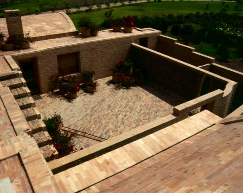 Un patio es un vacío al que llena la luz o es también una masa de aire. La arquitectura se hace presente en la medida en que la luz incide sobre ella. El contraste definitivo entre las masas sólidas y los vacíos es acentuado por las sombras que refuerzan el sentido tectónico de los pilares, de los muros, de las escaleras y, en general, de todas las fracturas de los volúmenes. Hay un sentido ceremonial en el tratamiento del conjunto. / Cota, Cundinamarca. Arquitecto, Rogelio Salmona.