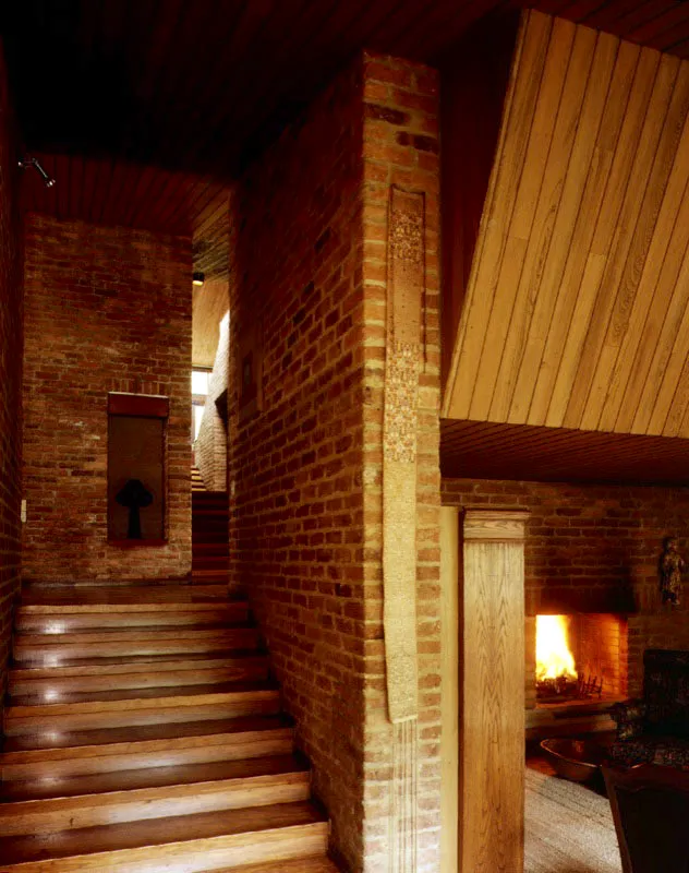 El ladrillo de fabricación artesanal conocido como "ladrillo de chircal", empleado profusamente, acentœa la extrema sencillez y sobriedad de los espacios interiores de la casa. El espacio del corredor con sus altos muros cerrados y sus cambios de nivel posee un espíritu evocadoramente arcaico. / Bogotá, D.C. Arquitecto, Dicken Castro Duque.