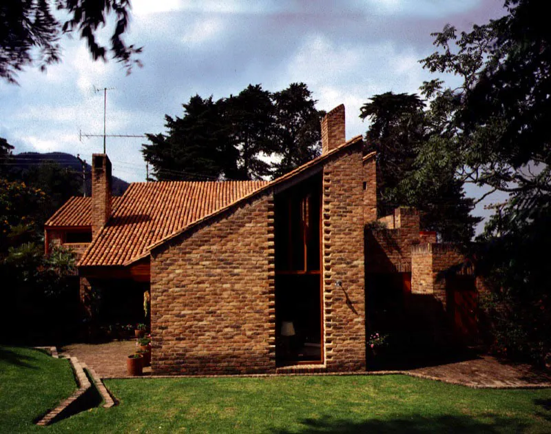 Un ejemplo integral de la arquitectura bogotana del ladrillo con sus principales elementos: elaboracin prolija de los volmenes exteriores con las fuertes diagonales generadas por la pendiente de las cubiertas, la puesta en escena de la textura del ladrillo comn tanto en el exterior como en el interior, el trabajo de entrantes y salientes en los muros, y la bsqueda de la luz. / Bogot, D.C. Arquitectos, Jorge Rueda, Carlos Morales. 