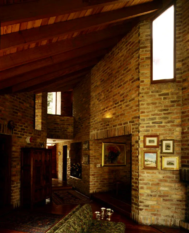 Un ejemplo integral de la arquitectura bogotana del ladrillo con sus principales elementos: elaboración prolija de los volœmenes exteriores con las fuertes diagonales generadas por la pendiente de las cubiertas, la puesta en escena de la textura del ladrillo común tanto en el exterior como en el interior, el trabajo de entrantes y salientes en los muros, y la búsqueda de la luz. / Bogotá, D.C. Arquitectos, Jorge Rueda, Carlos Morales.