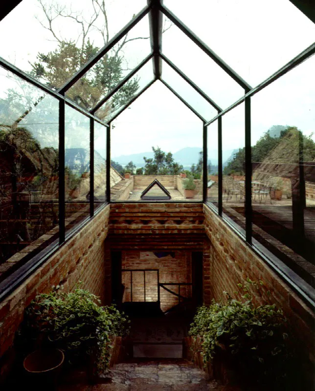 El espacio de la escalera cubierto por la marquesina es un admirable juego de inteligencia que combina aquello que se hunde en la tierra con aquello que se proyecta hacia el cielo en un contrapunto de positivo y negativo perfectamente logrado. / Bogotá, D.C. Arquitecto, Herbert Baresch.