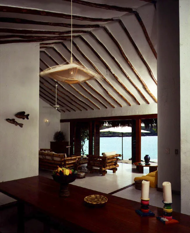El tratamiento rœstico de las vigas de la cubierta expuestas a la vista contrasta con el cuidadoso trabajo de madera de las puertas y ventanas. La presencia del mar atrae la vista directa e indirecta de todos los espacios. / Barú, Bolívar. Arquitecta, Loli Obregón.