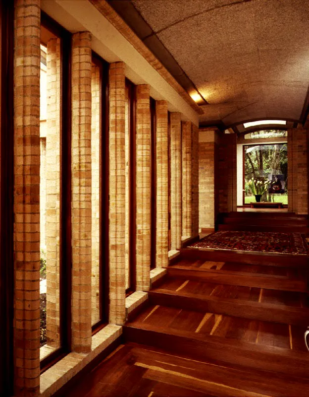 El ritmo dado por los peldaños de la escalinata se adopta como pauta para marcar, con las ventanas, el ritmo del corredor cuyo remate distante denota el interés por la axialidad en el interior de la casa. / Bogotá, D.C. Arquitecto, Billy Escobar.