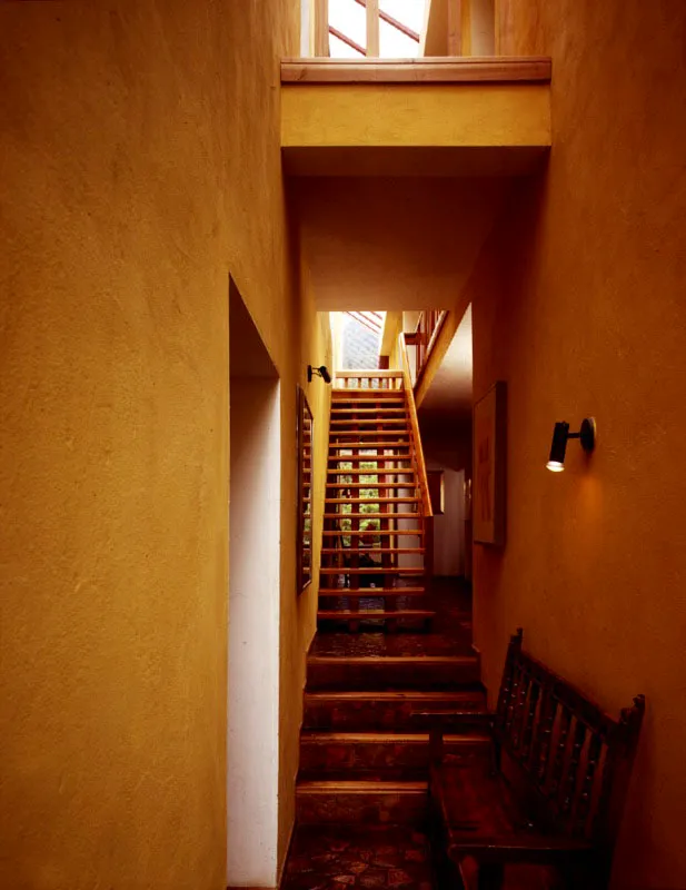 Según un visitante, la casa está "amarrada por la luz". A su vez el espacio del salón se encuentra amarrado por los libros que recubren las paredes. La chimenea y la escalera se entrometen en él. Chía, Cundinamarca. Arquitectos, Alberto Saldarriaga, Rodrigo Rubio.