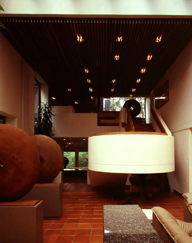 La marquesina, uno de los aportes relativamente recientes al diseño interior de la casa, se trabaja como parte importante de su espacialidad. Las líneas formadas por sus apoyos tienen eco en las líneas de las maderas del cielo raso. El efecto del volumen flotante se repite en el tratamiento de la escalera. / Bogotá, D.C. Arquitecto, Luis Kopec.