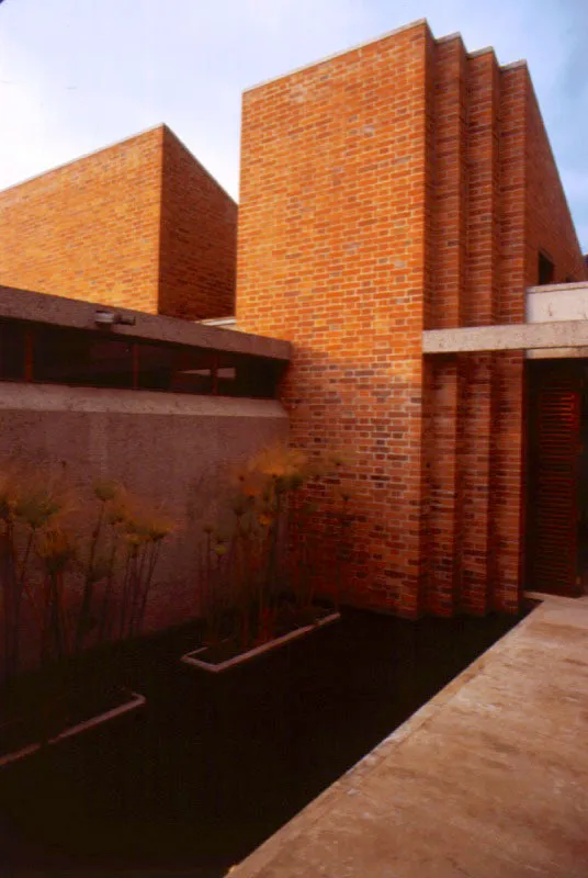 En la casa se reúnen y reelaboran temas espaciales como el patio central y las cubiertas inclinadas que convergen en él, con un tratamiento nuevo, en materiales y detalles. Las masas texturadas en ladrillo se trabajan con cierto virtuosismo que acentúa los contrastes de luz y sombra. En el interior hay un retorno a la austeridad de las grandes superficies blancas. / Bogotá, D.C. Arquitecto, Carlos Campuzano.