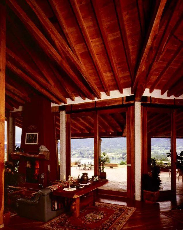 En dos casas distintas se aprecian intenciones similares. Las vigas de madera que sirven de soporte a entrepisos y cubiertas se trabajan como directrices de la espacialidad interior. Horizontales o inclinadas, paralelas u oblicuas, ellas marcan ritmos y direcciones y unen su textura a las otras que se combinan en cada recinto. / La Fe, Antioquia. Arquitectos, Alejandro Echeverri, Juan Bernardo Echeverri