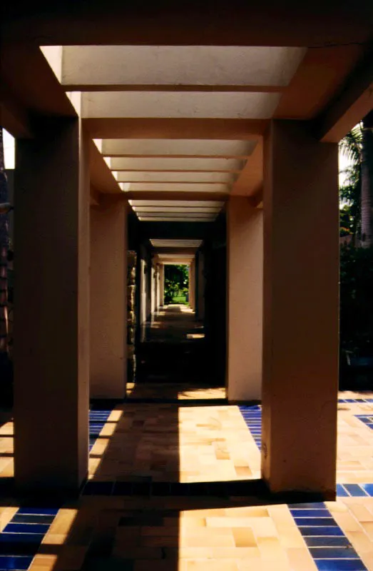 El corredor separado de la casa es un pretexto para elaborar juegos geométricos con los soportes verticales y los elementos horizontales de la pérgola y del diseño de pisos. También es un pretexto para romper esa geometría con la curva natural de una hamaca. / Anapoima, Cundinamarca. Arquitecta, Mónica Gómez de Espinosa.