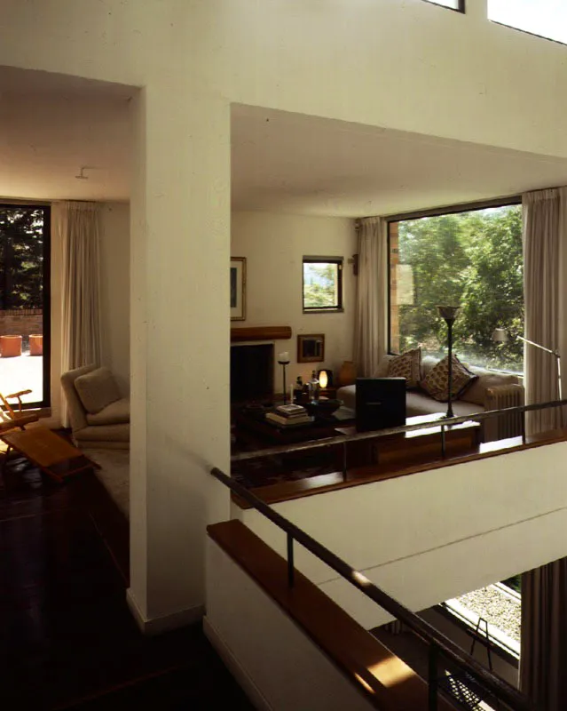 La arquitectura de la casa es decididamente moderna. La manera clara y directa como se trabajan las formas, el dominio del blanco y el manejo de las líneas formadas por las carpinterías metálica y de madera denotan afinidades con la estética de lo abstracto. Un plano rojo irrumpe con su vibración cromática en la serenidad del interior de la casa. / Bogotá, D.C. Arquitecto, Luis Restrepo.