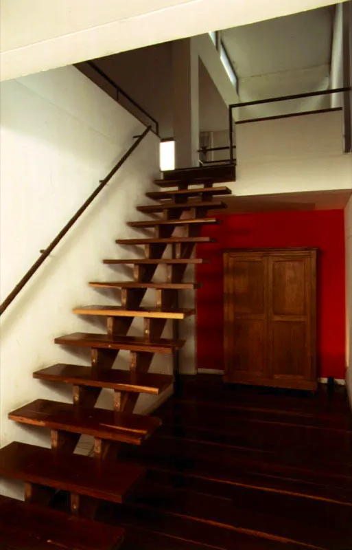 La arquitectura de la casa es decididamente moderna. La manera clara y directa como se trabajan las formas, el dominio del blanco y el manejo de las líneas formadas por las carpinterías metálica y de madera denotan afinidades con la estética de lo abstracto. Un plano rojo irrumpe con su vibración cromática en la serenidad del interior de la casa. / Bogotá, D.C. Arquitecto, Luis Restrepo.