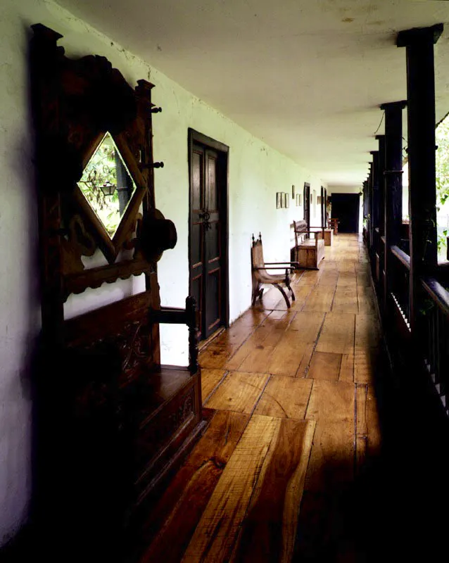 Los Laureles. Facatativá, Cundinamarca.
Es casa “alta y baja”
en torno a un patio.
El crecimiento gradual de la casa es evidente en la informalidad de las relaciones entre
los volúmenes que
la conforman.
Las galerías altas en torno al patio fueron “republicanizadas”, y ostentan ahora cielos rasos planos impropios de las casas de época colonial. Sería una indirecta influencia islámica dejar que la vegetación domine las formas construidas.