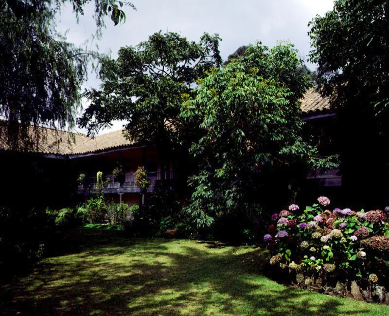Los Laureles. Facatativá, Cundinamarca.
Es casa “alta y baja”
en torno a un patio.
El crecimiento gradual de la casa es evidente en la informalidad de las relaciones entre
los volúmenes que
la conforman.
Las galerías altas en torno al patio fueron “republicanizadas”, y ostentan ahora cielos rasos planos impropios de las casas de época colonial. Sería una indirecta influencia islámica dejar que la vegetación domine las formas construidas.