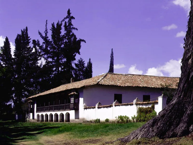 Casa de Britalia, Duitama, Boyac. 
La hacienda a la cual corresponde fue establecida a comienzos del siglo XVIII, aunque la casa misma puede ser ms reciente. Conserva su organizacin espacial y volumetra originales, pero el hermoso y suave paisaje donde se localiz inicialmente est actualmente en proceso de deterioro y destruccin debido al crecimiento de los suburbios de Duitama. Aprovechando el declive de un altozano, Britalia incluye un piso bajo parcial sobre el cual se coloca la galera de la fachada principal, rasgo observable 
en otras casas 
ilustradas en este volumen. Esto 
permite aprovecharlo como depsito y lograr una volumetra ms airosa. Los arcos rebajados, as como 
los curiosos gabinetes propios de la casa urbana santaferea, se sitan simtricamente en la fachada con reformas introducidas en el siglo XIX o comienzos de XX. 
El patio interior retiene el sistema constructivo original de poste y dintel en madera, pero la pila de piedra es un detalle decorativo reciente.  