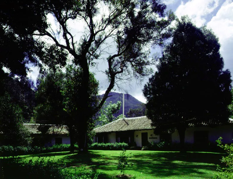 El Portezuelo, Ubaté, Cundinamarca.
La localización favorita de las casas de la región es la de “pie de cerro” o “pie de monte”, donde con más frecuencia se hallan manas de agua
o arroyos y se está parcialmente al abrigo del viento vesperal o el frío del amanecer. En Boyacá y el norte de Cundinamarca es común la casa de planta compacta, con un rancho o pabellón aparte, pero adyacente, para el mayordomo y su familia, depósitos y caballerizas.
El Portezuelo parece haber sido conformada al terminar el siglo XVIII. La casa en su forma actual puede datar de la misma época.