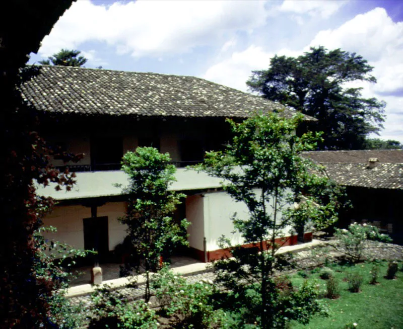 Calibío. Popayán, Cauca.
Las grandes galerías del piso alto de Calibío son prácticamente idénticas a las que se podrían hallar aún hoy en campos y ciudades desde La Mancha hasta Córdoba, en tierras hispánicas, pero fueron creadas de esa manera y no otra porque el paisaje caucano así lo exigía ante la memoria y la intuición de sus constructores. Por ello son, como el resto
de la casa, inseparables del lugar que ésta ocupa. La casa de hacienda es un escenario para una modalidad existencial cotidiana que no podría ni quiso ser jamás la misma, a un lado y otro del Mar Océano. En Casa Colonial se dijo: “Las casas neogranadinas mostrarán una… mezcla de rasgos, mitad castellanos, mitad andaluces, es decir, algo que no
se había dado ni
en Castilla ni en Andalucía. Se conformó así el
matiz original…
del florecimiento,
en el nuevo continente, de un género arquitectónico tan antiguo como la humanidad misma.
En éste fue siempre clara su estirpe, pero evidente también su íntima relación con la tierra donde fue levantado”.