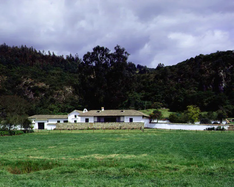 El Abra, Zipaquirá, Cundinamarca. Definible como un caso límite entre una casa de hacienda colonial modernizada
y lo que en efecto
es una casa de
campo actual dotada
de una volumetría
y localización tradicionales. El Abra pertenece al género ambiguo en el cual habría que incluir
las casas de Fute, Canoas, Cortés, Buenavista, La Conchita y otras residencias campestres cundinamarquesas.
La casa conserva la relación volumétrica más o menos original con el espléndido lugar donde se localiza.
La capilla y el muro atrial de piedra son intervenciones modernas (década
de los sesenta), siendo notable la alteración provocada por este último en la organización de los espacios circundantes
al frente de la casa.
