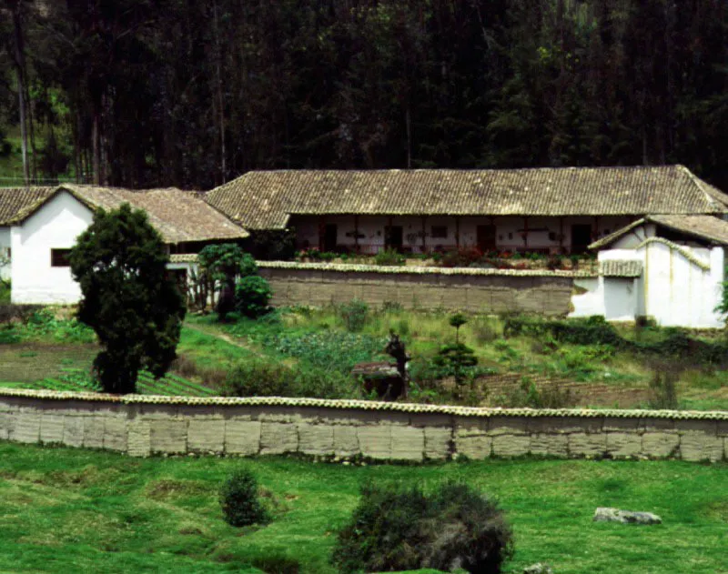 Los Aposentos, Chocont, Cundinamarca. 
Son varias las casas 
de hacienda en Cundinamarca que llevan este nombre, 
el cual es tambin frecuente en Castilla 
y Andaluca. Al comienzo del siglo XVIII existan haciendas Aposentos 
en Simijaca (ilustrada en pginas anteriores), Sop y Chocont (la que se muestra aqu), 
y otras ms aparecieron en la regin durante el siglo XIX. Al igual que con Casablanca, la proliferacin de ciertos nombres de propiedades rurales tendra las mismas razones que la abundancia de Pedros o Juanes entre los pobladores espaoles de la Nueva Granada.
Los Aposentos, de los alrededores de Chocont, cuya edificacin original parece datar de la primera mitad del siglo XVIII, aunque la hacienda misma se conforma a mediados del XVII, carece del tono acadmico fuera de serie de su homnimo de Simijaca y pertenece ms al gnero clsico de casa sabanera. Como tal, posee esplndidas proporciones modulares en las columnatas de las galeras visibles aqu, y un delicado acomodo al paisaje circundante. Parece ser que la casa original consista solamente del tramo longitudinal visible a derecha, lo cual asimilara la casa al tipo de planta compacta con grandes galeras en sus lados longitudinales. Esto corrobora la idea de que no existe una organizacin espacial de casas de hacienda propia o tpica de una regin o zona climtica en particular, puesto que las casas de planta compacta existen desde el sur 
de la Nueva Granada hasta el altiplano cundiboyacense. El crecimiento de la 
casa a travs de las dcadas se ha mantenido afortunadamente dentro de lmites volumtricos y una continuidad formal que hacen de Los Aposentos uno de los ejemplos ms depurados de casa de hacienda cundinamarquesa.  