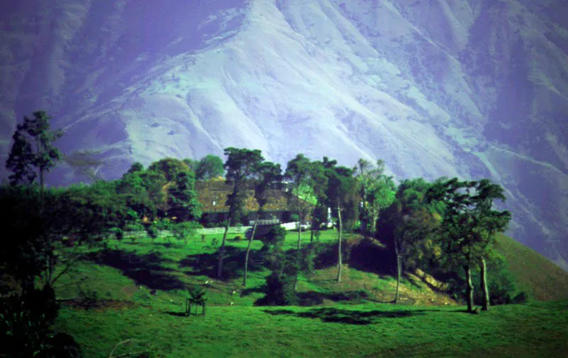 La Loma, segunda
casa con este nombre, alrededores de Titiribí, Antioquia.
La localización de la casa en un paraje de abrupta topografía bordea lo teatral. La casa invade el lugar haciendo uso de los mismos recursos arquitectónicos que le permitirían estar en el paisaje plano del Valle del Cauca o en el altiplano boyacense, incluyendo sus amplios tejados y galerías exteriores, así como el tradicional patio interior. La casa en una loma en cercanías de Titiribí fue, como la primera, construida en el siglo XVIII, en la región neogranadina donde se conformó la mayoría de haciendas mixtas de tipo análogo a las de México: mineras y agrícolas a la vez. Muchas de ellas, por la gran dificultad de acceso desde los pueblos, adquirieron carácter, mobiliario y usanzas pseudo-urbanos, puesto que sus propietarios preferían vivir en ellas durante temporadas muy prolongadas a emprender reiteradamente las azarosas expediciones a las cabeceras de provincia. Esta tuvo por ello mismo, y al igual que otras en la región antioqueña, un tratamiento ecléctico interior de época republicana.