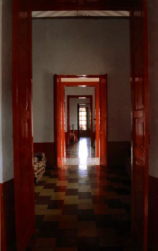 La Loma, segunda
casa con este nombre, alrededores de Titiribí, Antioquia.
La localización de la casa en un paraje de abrupta topografía bordea lo teatral. La casa invade el lugar haciendo uso de los mismos recursos arquitectónicos que le permitirían estar en el paisaje plano del Valle del Cauca o en el altiplano boyacense, incluyendo sus amplios tejados y galerías exteriores, así como el tradicional patio interior. La casa en una loma en cercanías de Titiribí fue, como la primera, construida en el siglo XVIII, en la región neogranadina donde se conformó la mayoría de haciendas mixtas de tipo análogo a las de México: mineras y agrícolas a la vez. Muchas de ellas, por la gran dificultad de acceso desde los pueblos, adquirieron carácter, mobiliario y usanzas pseudo-urbanos, puesto que sus propietarios preferían vivir en ellas durante temporadas muy prolongadas a emprender reiteradamente las azarosas expediciones a las cabeceras de provincia. Esta tuvo por ello mismo, y al igual que otras en la región antioqueña, un tratamiento ecléctico interior de época republicana.