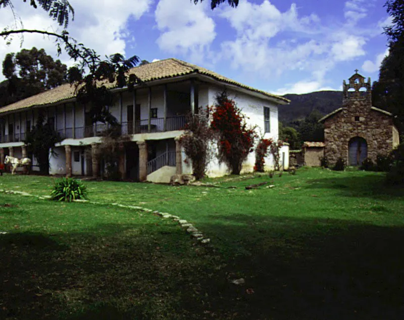 El Rabanal, Ubaté, Cundinamarca.
La transición arquitectónica de esta casa no consistió en imposiciones academizantes sino en alteraciones técnicas que trastrocaron la austera geometría de la construcción de época colonial. El volumen de la casa siguió siendo el mismo, pero los pies derechos de la galería del piso alto se multiplicaron en número y este peso adicional hizo necesario el “refuerzo” del piso bajo. Las improvisadas columnas de piedra indican una total indiferencia o ignorancia respecto del funcionamiento estructural de la antigua casa pero resultan pintorescas. La República improvisó donde la Colonia sabía exactamente lo que hacía.