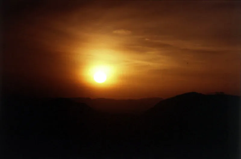 Rayos alargados del sol al amanecer sobre el relieve de los cerros. 