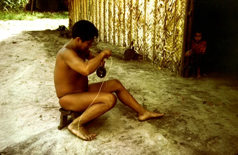 Chamán Barasana asegurando el mango de su maraca ritual. Pira-paraná, Vaupés.