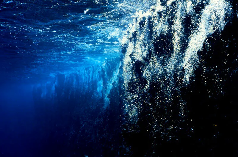 Cortinas de burbujas se descuelgan 
desde la superficie, en el contorno sumergido 
de la isla de Malpelo, cuando la cabalgata de olas ocenicas se 
derrumba en sus acantilados, a ms de 300 millas de la costa Pacfica colombia Aldo Brando