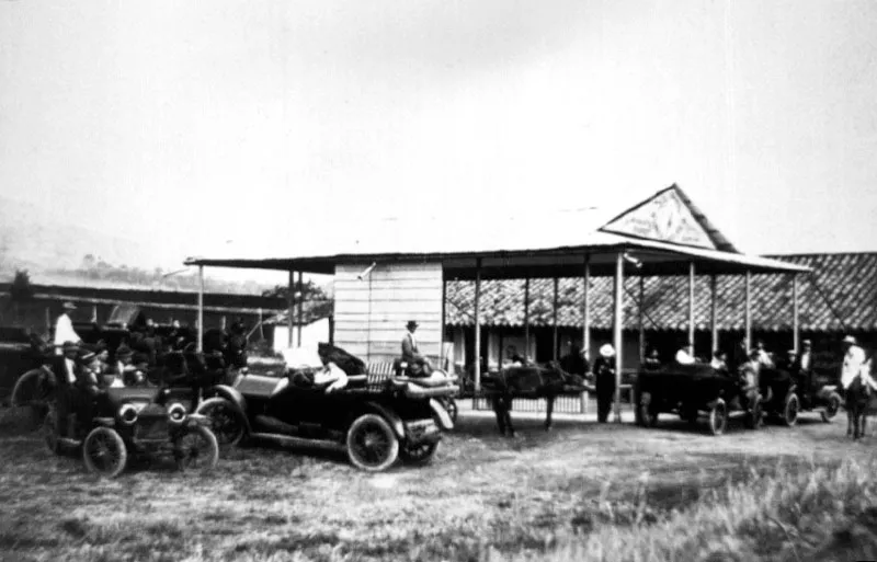 Automóviles de principios de siglo entre ellos Ford Modelo T y vehículos de tracción animal.