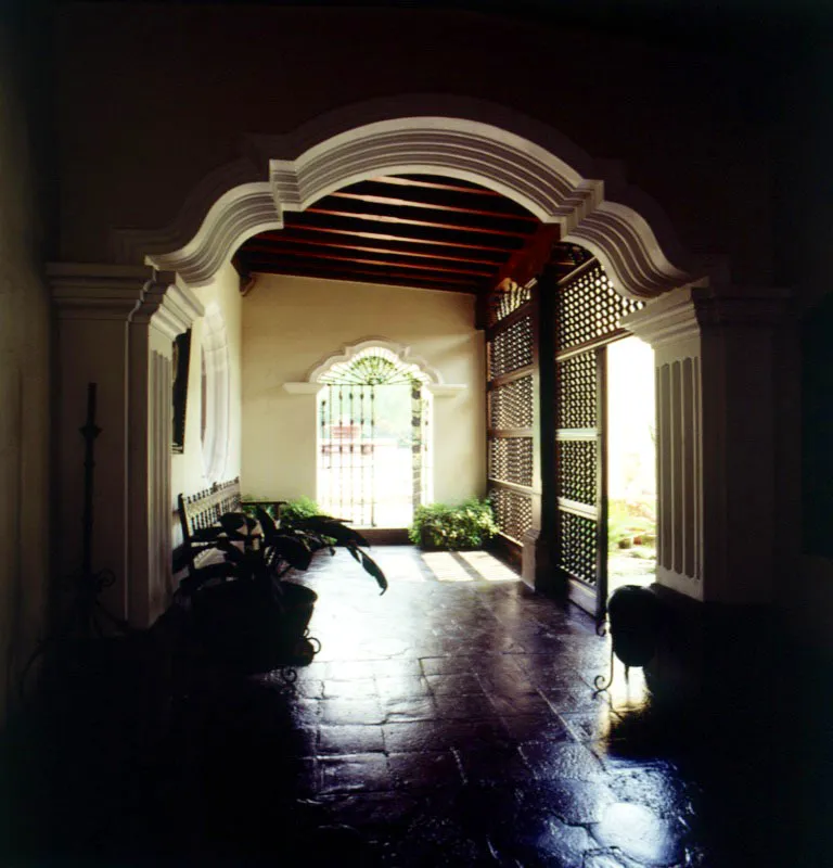 Corredor de una casa actual en Antigua, donde se incorporaron arcos mixtilíneos, tan usados en Guatemala durante la última etapa del barroco, baldosa de barro y puertas con barrotes de madera torneada.