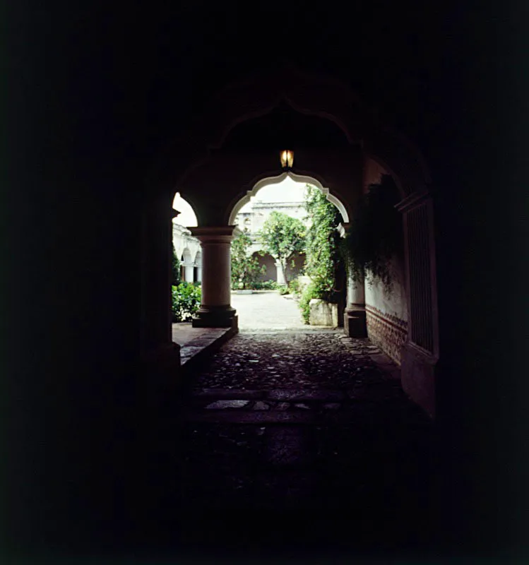 Zaguán empedrado y vista parcial del patio de lo que fue el colegio Tridentino, en Santiago de Guatemala, hoy Antigua, diseñado por el Maestro Mayor Bernardo Ramírez, alrededor de 1750, con arcos mixtilíneos.